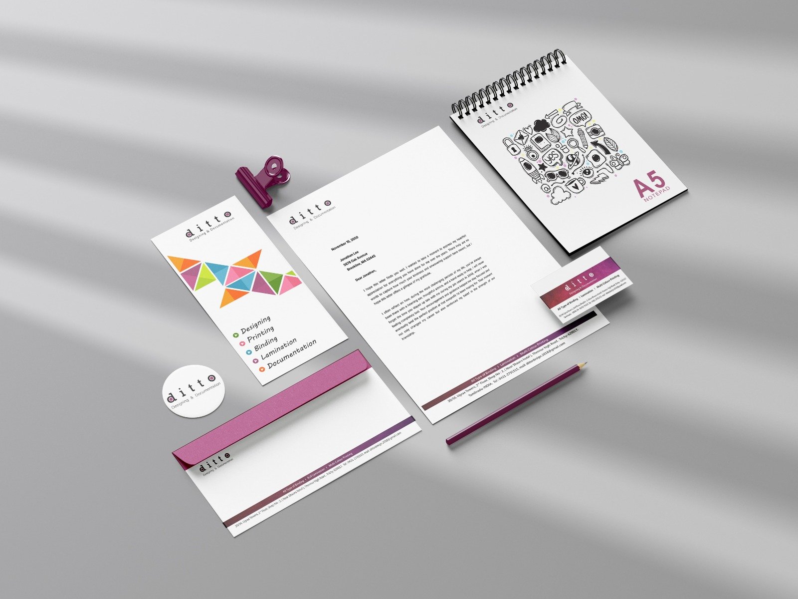 Ditto Design branded stationery — letterhead, A5 spiral notepad, tri-fold brochure, business card, envelope and badge laid out together